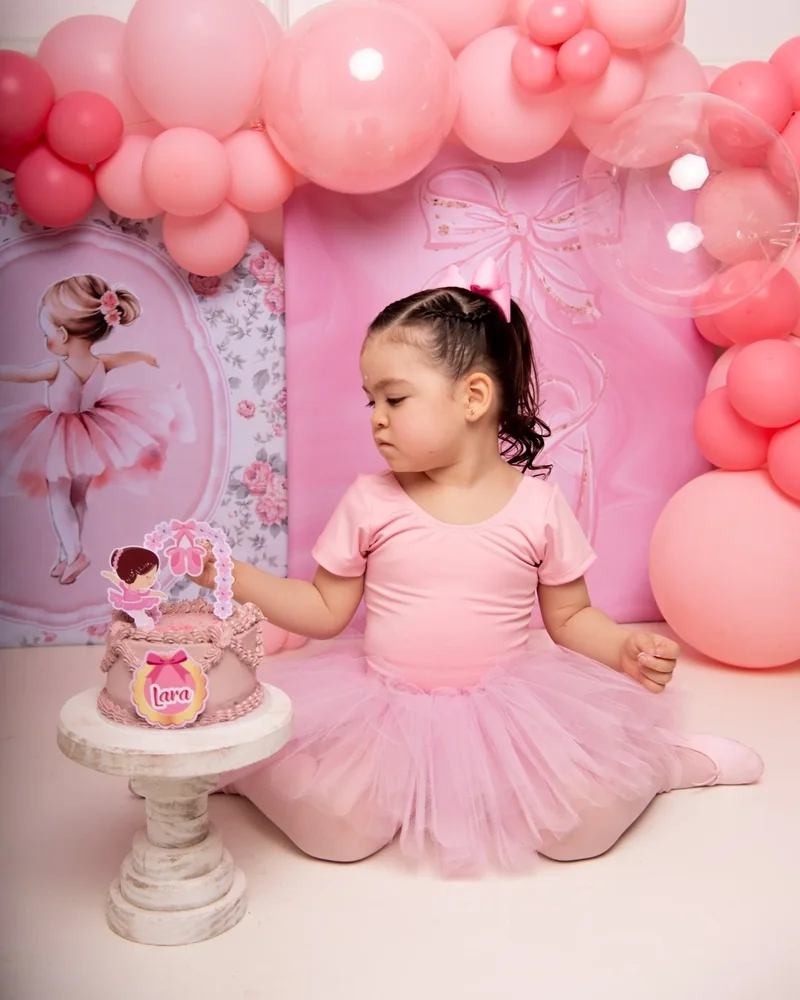 Niña con tutú rosa sentada junto a su torta, set de bailarina