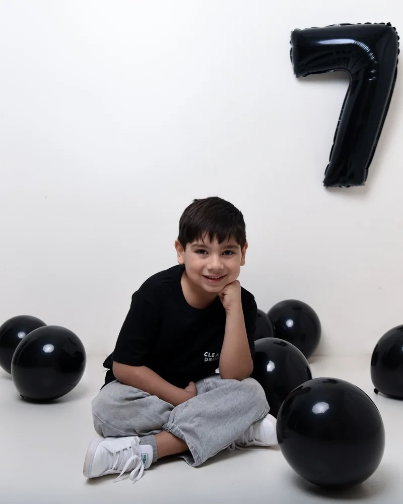 Niño de siete años con un globo del número siete