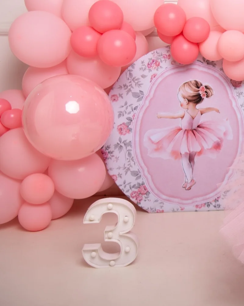Niña con tutú rosa en un set de bailarina con globos