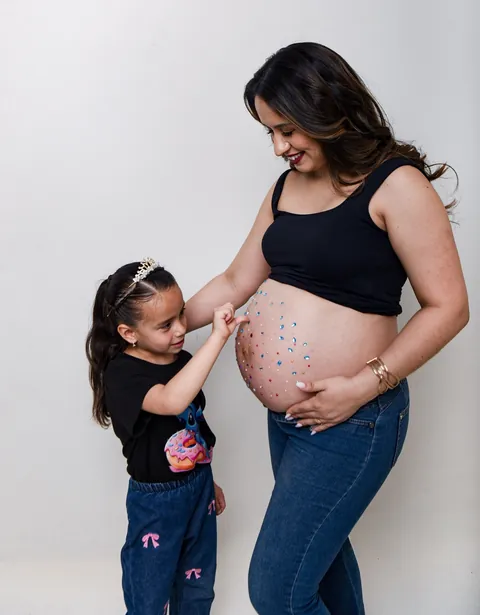 Familia esperando un bebé, el papá besa la panza