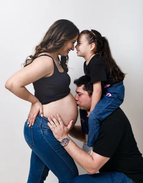 Niña acariciando la panza de su mamá embarazada