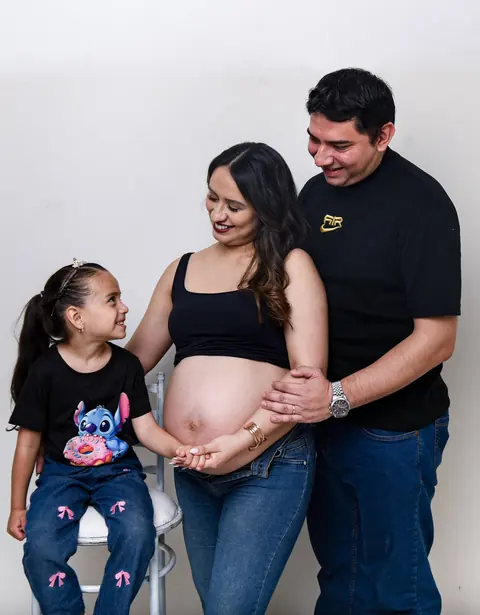 Familia esperando un bebé, con la hija mayor tocando la panza