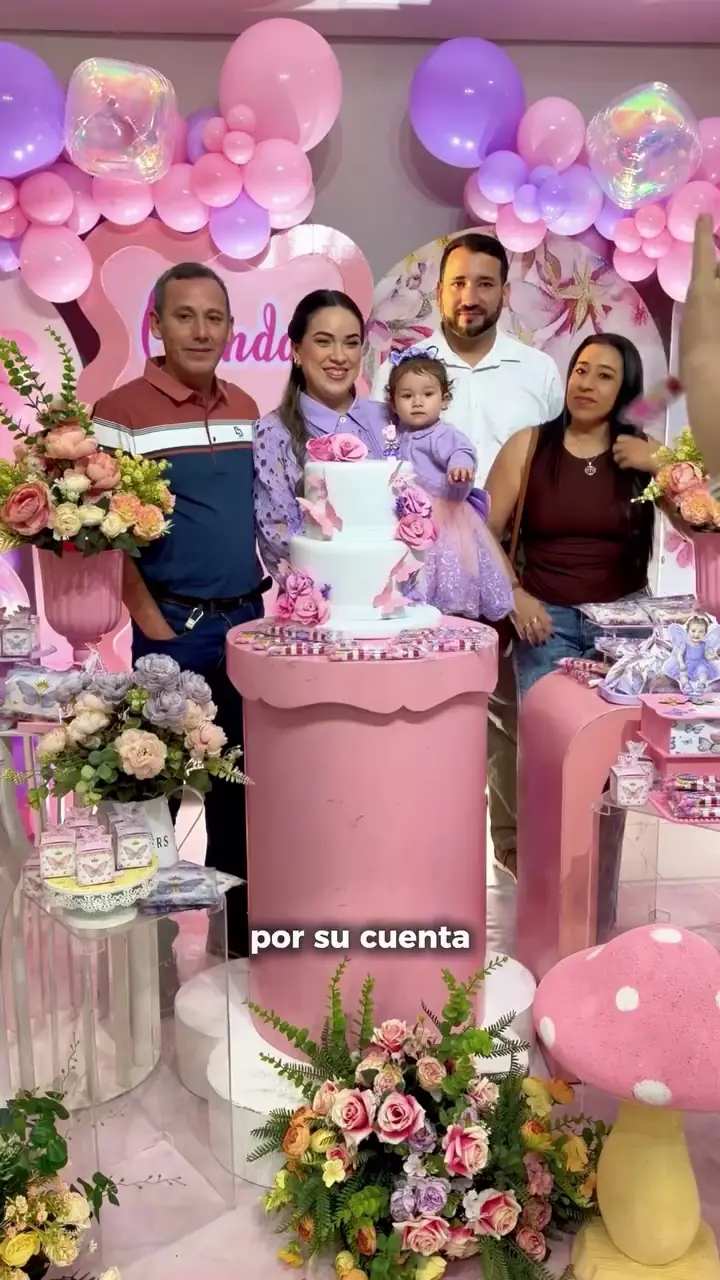 Familia festejando un cumpleaños con decoración rosada